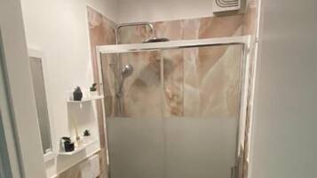 A bathroom with a shower, toilet, and sink.