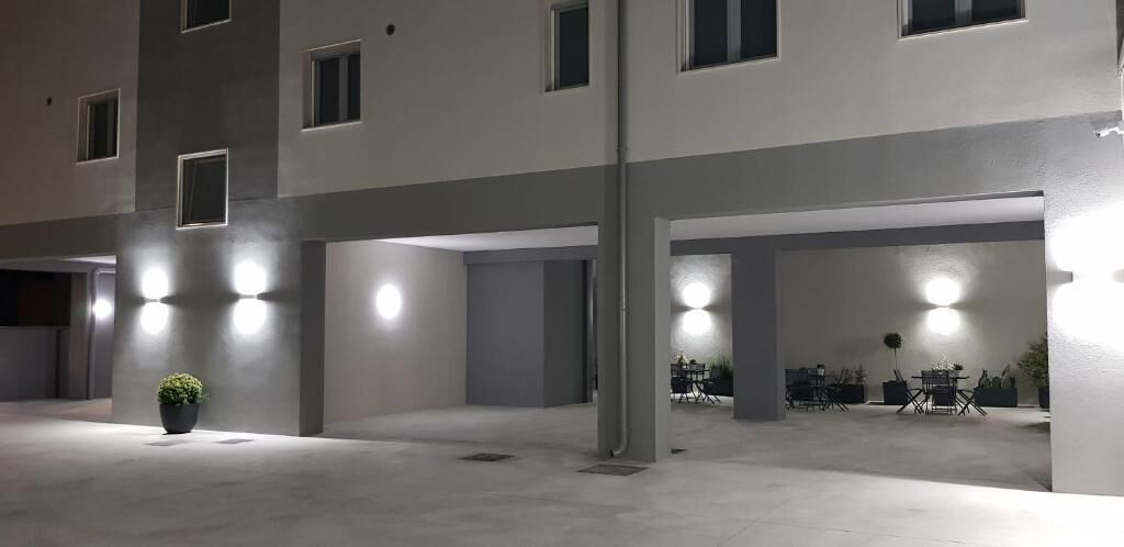 A multi-level parking structure with illuminated bollards and a potted plant.