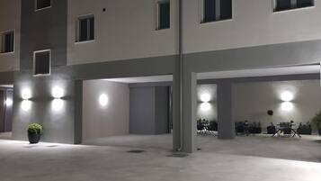 A multi-level parking structure with illuminated bollards and a potted plant.