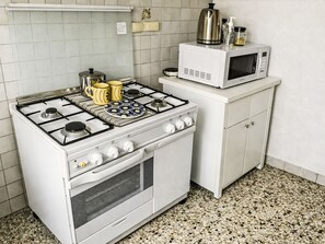 A kitchen with a gas stove, oven, microwave, and granite countertop. - Casa Beppina Cortona by Interhome (Cortona)