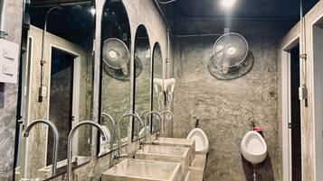 A public restroom with multiple sinks, mirrors, and fans.