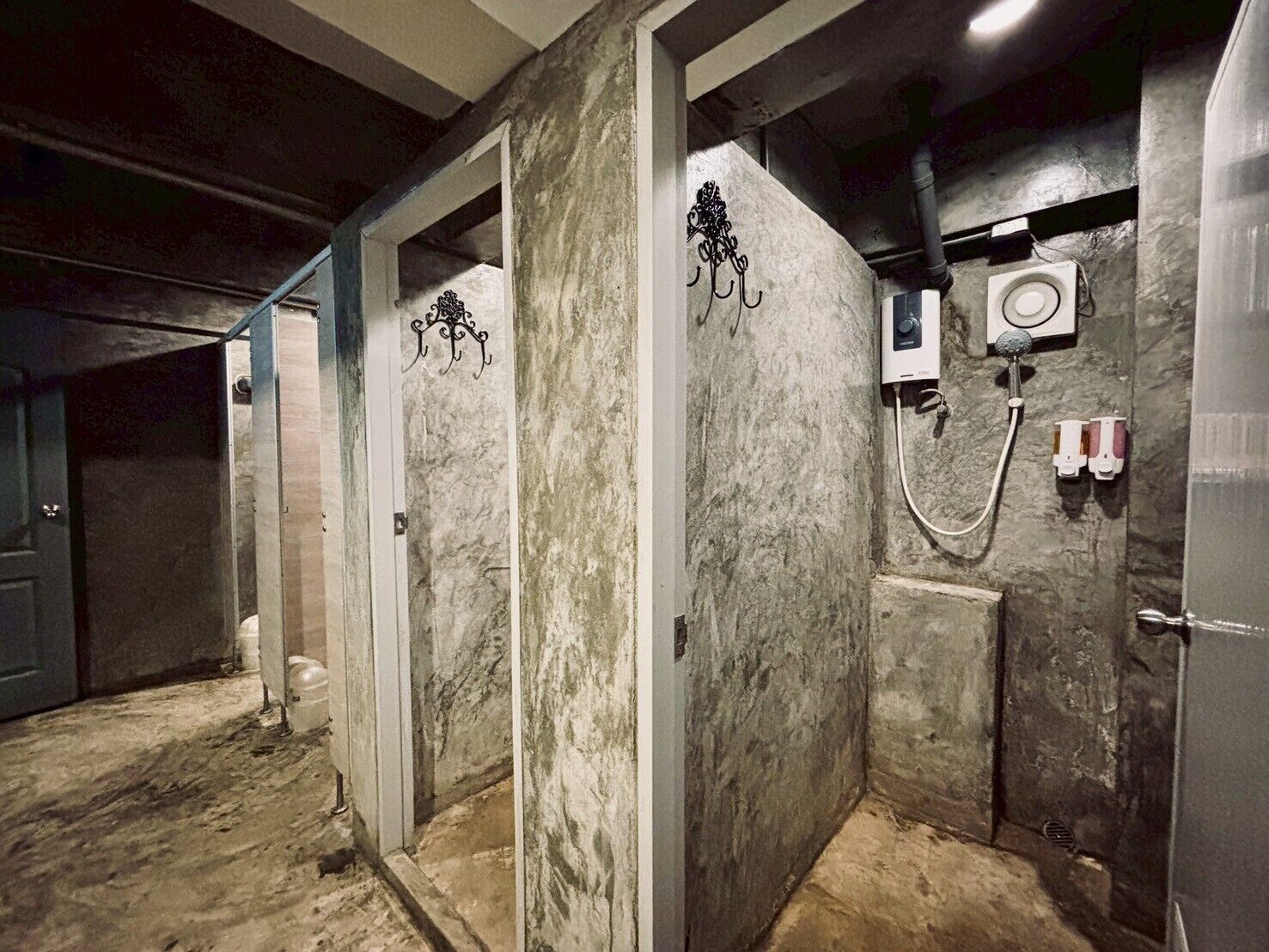 A bathroom with marble walls, a shower, and a toilet.