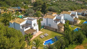 Zona residencial amb cases modernes, una piscina i vistes al mar.