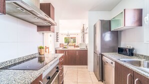 Eine moderne Küche mit Granit-Arbeitsplatten, Edelstahlgeräten und Holzausstattung.