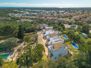 Un quartier résidentiel avec des maisons blanches, une piscine et une vue dégagée sur la mer.