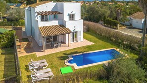 A two-story house with a swimming pool, patio furniture, and a view of the surrounding landscape. - Son Ganxo I by Interhome (Cala Murada)