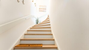 A staircase with wooden steps and a doormat at the bottom. - House Harvestehude apartment "Küstenglück" (Sylt)