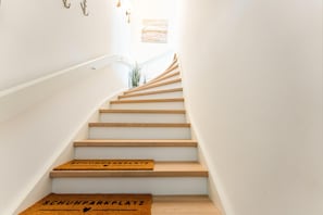 Eine Treppe mit Holzbodenstufen und einer Fußmatte am Fuß.
