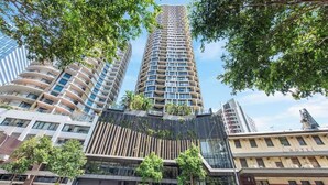A modern hotel with a curved facade, large windows, and a prominent entrance. - The Story Suite! 2Bed/2Bath/2Car/Pool/VIEWS ~ CBD (Brisbane City)