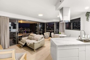 A modern apartment with a living area, sofa, dining table, and kitchen with a large window. - Amazing! 2Bed/2Bath/1Car/Balcony/Views ~ CBD (Brisbane City)