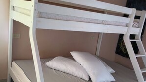 Ein Stockbett mit einer Leiter, einer Matratze und Kissen.