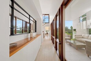 Ein modernes Interieur mit einer langen Diele, einer Holztresen und einer Sitzecke mit Sofa und Couchtisch.