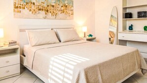 Une chambre à coucher comprenant un lit, des tables de chevet, une commode, un bureau avec une chaise, un miroir et un tableau accroché au mur.