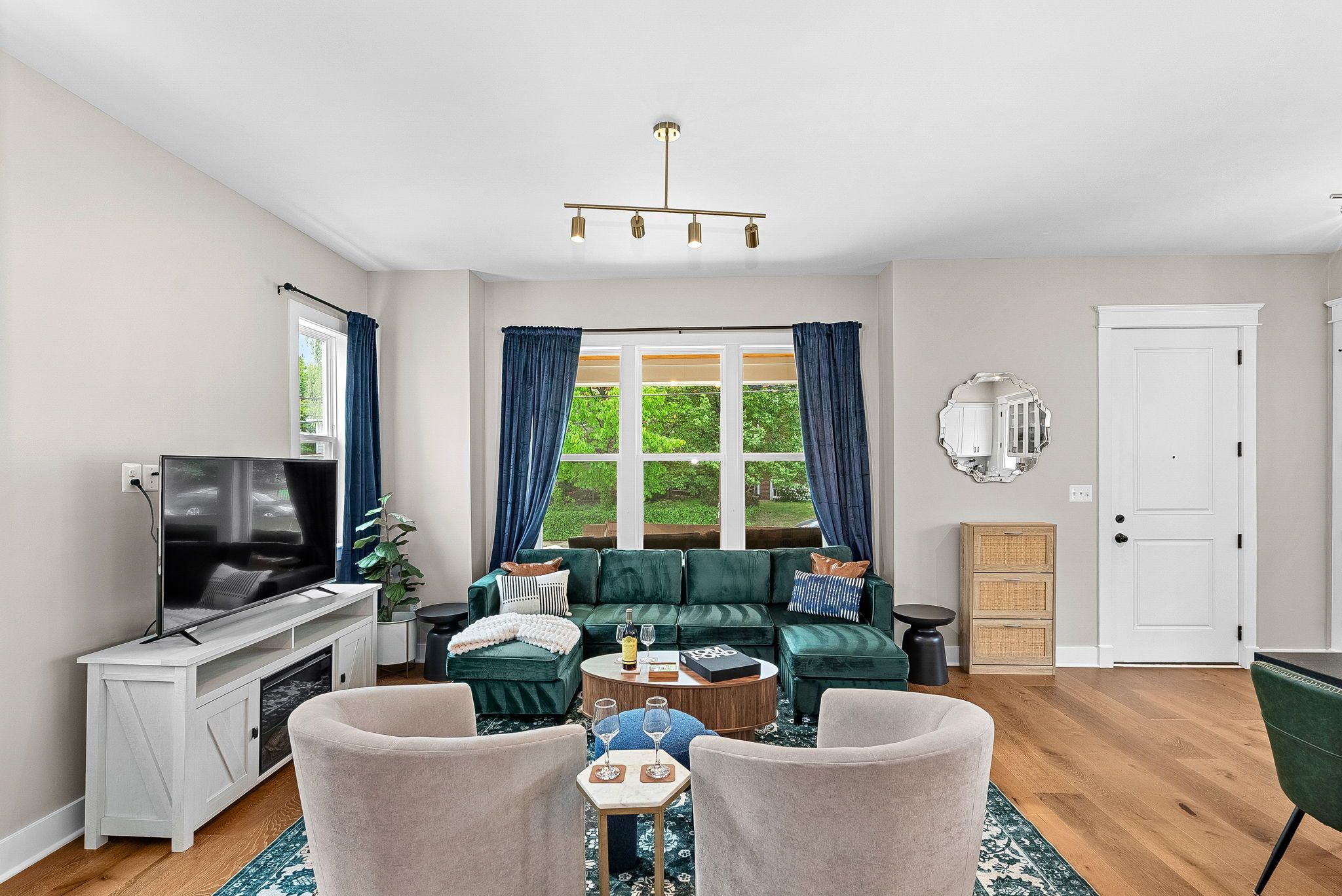 Ein Wohnzimmer mit Fernseher, einer Couch, einem Couchtisch und einem Essbereich mit Stühlen.