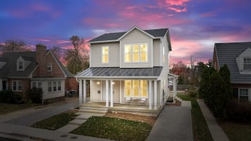 A two-story house with a covered porch and a garage.