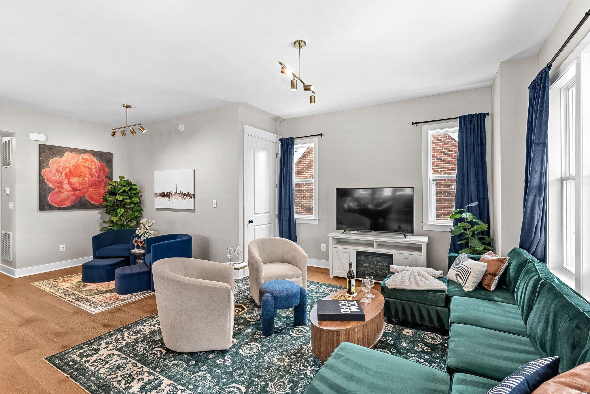 A modern living room with a sofa, armchair, coffee table, and a flat-screen TV.