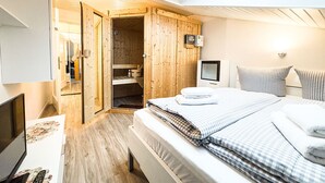 Un dormitorio con cama, televisión, escritorio y armario de madera.