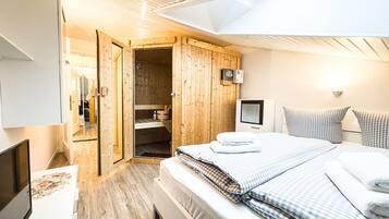 Ein Schlafzimmer mit einem Bett, einem Fernseher, einem Schreibtisch und einem Holzschrank.