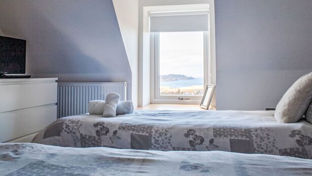 A bedroom with a bed, a radiator, a television, and a window with a view. - Ben Edra Croft by Interhome (North Skye)