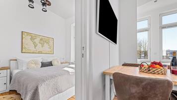 Ein Schlafzimmer mit einem Bett, einer Wandkarte und einem Essbereich mit Tisch und Stühlen.