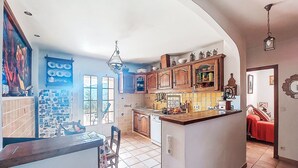 A spacious kitchen with a large island, wooden cabinets, and a view of the outdoors. - L´Argentière by Interhome (Les Adrets)