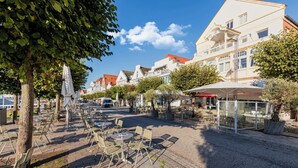 Eine Straße mit Außenbereich, Bäumen und Gebäuden mit Balkonen.
