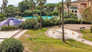 A resort with a swimming pool, palm trees, and a building with a tiled roof. - Les Rivages des Issambres by Interhome (Les Issambres)