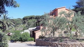 A Mediterranean-style villa with a stone facade, a balcony, and surrounding greenery. - Casa Roberta apartment 2 (Capoliveri isola d'Elba)