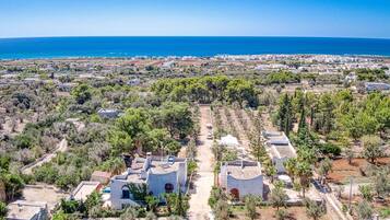 An aerial view of a coastal town with buildings, roads, and a clear blue sky.