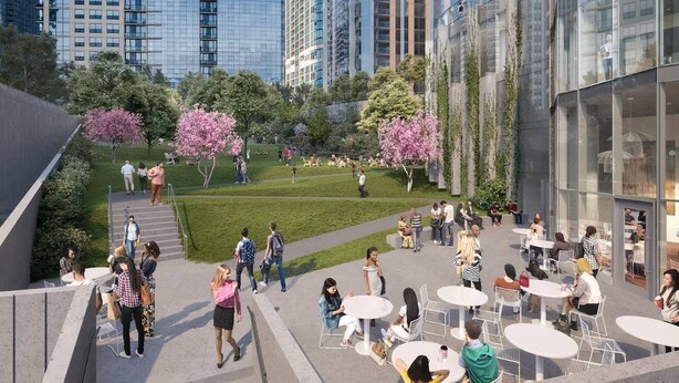 Una plaza urbana moderna con mobiliario exterior, zonas verdes y edificios altos al fondo.