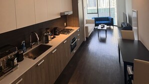 Una cocina moderna con comedor, sofá y televisor.