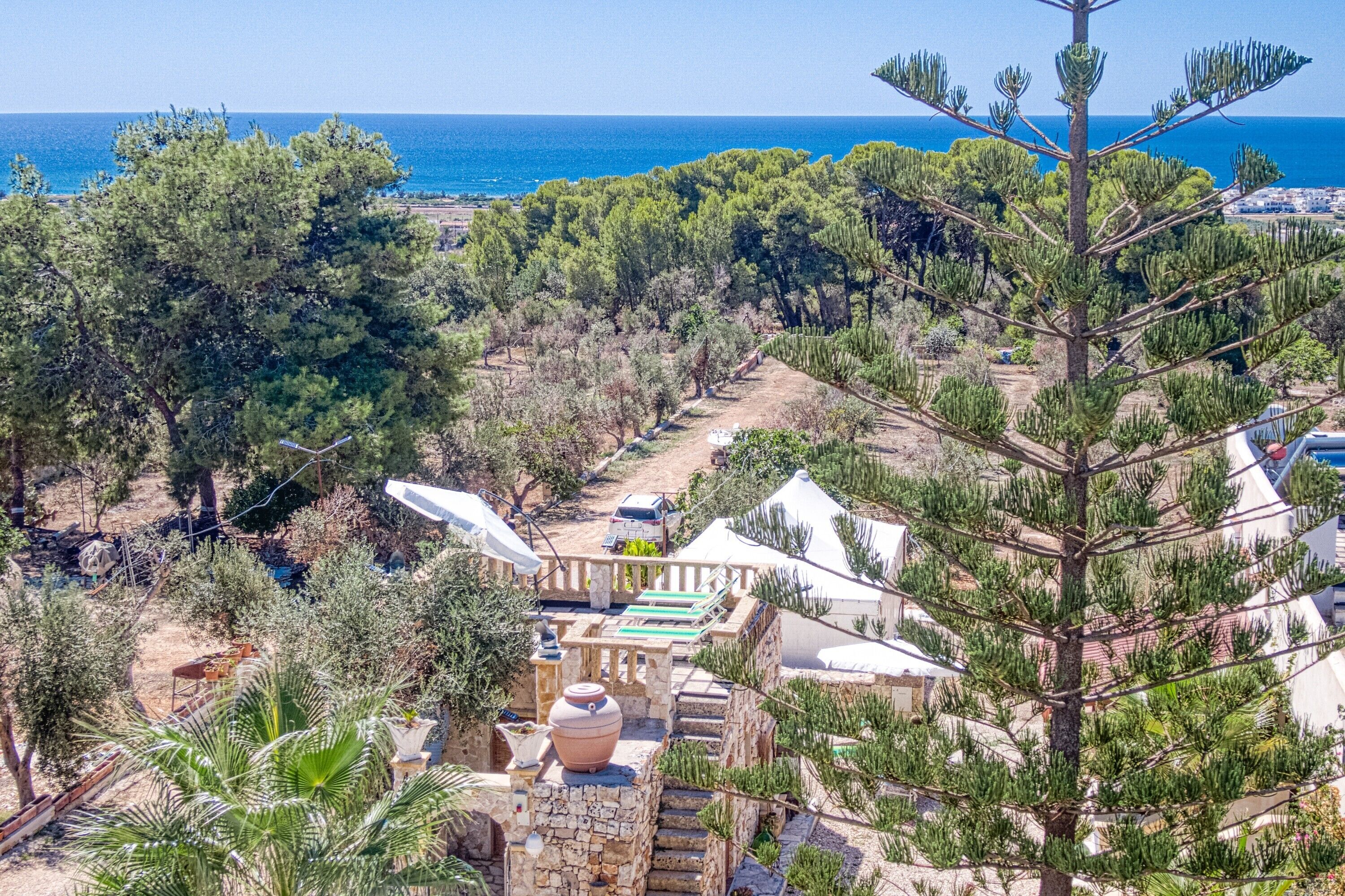 A coastal property with stone buildings, a pathway, and a view of the sea.