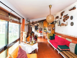 Amplia sala de estar con sofá, mesa de comedor y cocina al fondo.