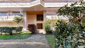 A modern building with a central entrance, a covered walkway, and a garden area with various plants. - Maris Stella by Interhome (Arcachon)