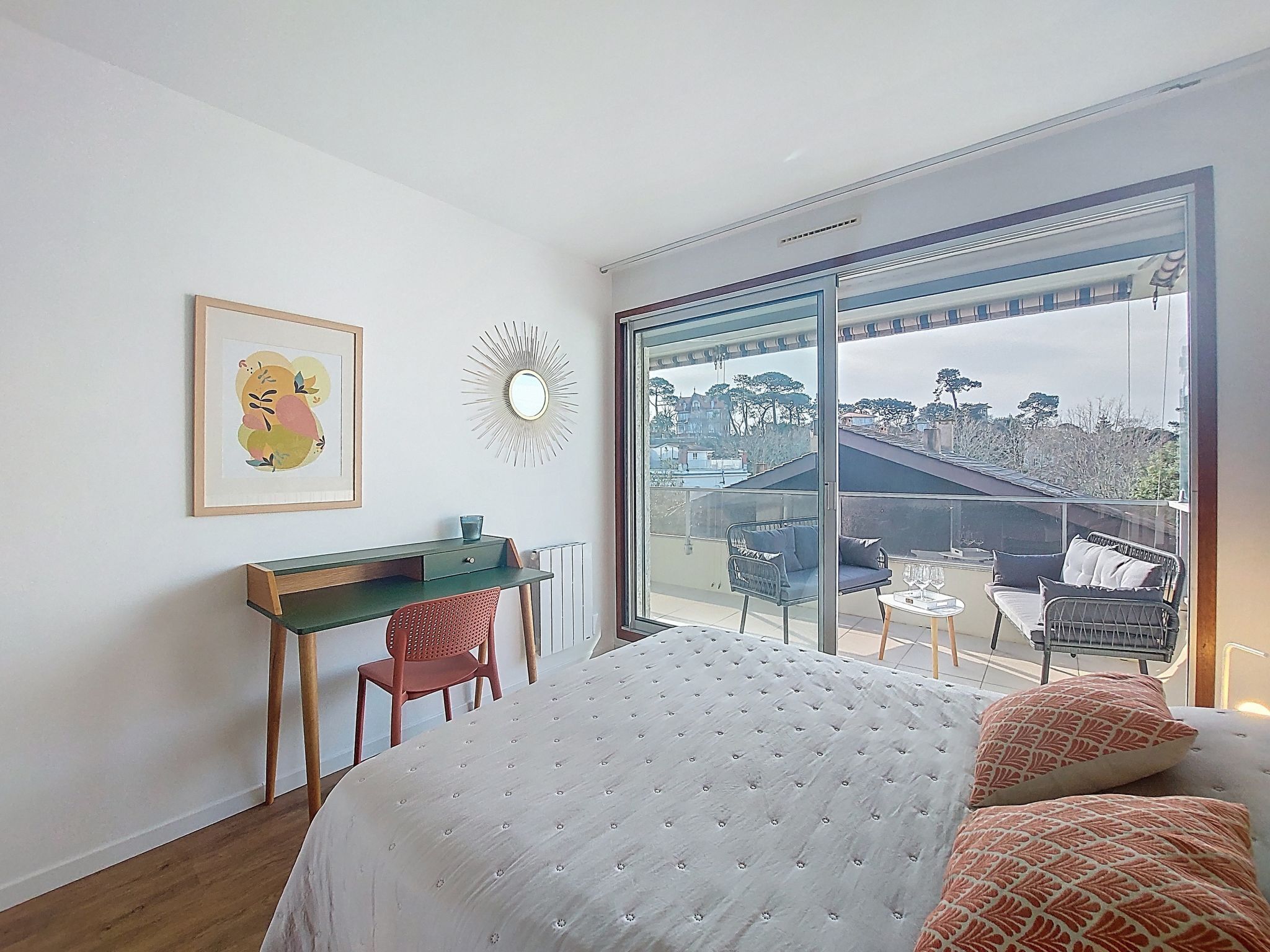 Une chambre à coucher comprenant un lit, un bureau, une chaise, un radiateur, une fenêtre et une vue sur l’extérieur.