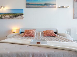A bed with two pillows, a bedside lamp, and a glass of water on a bedside table. - Côte d'Argent by Interhome (Arcachon)