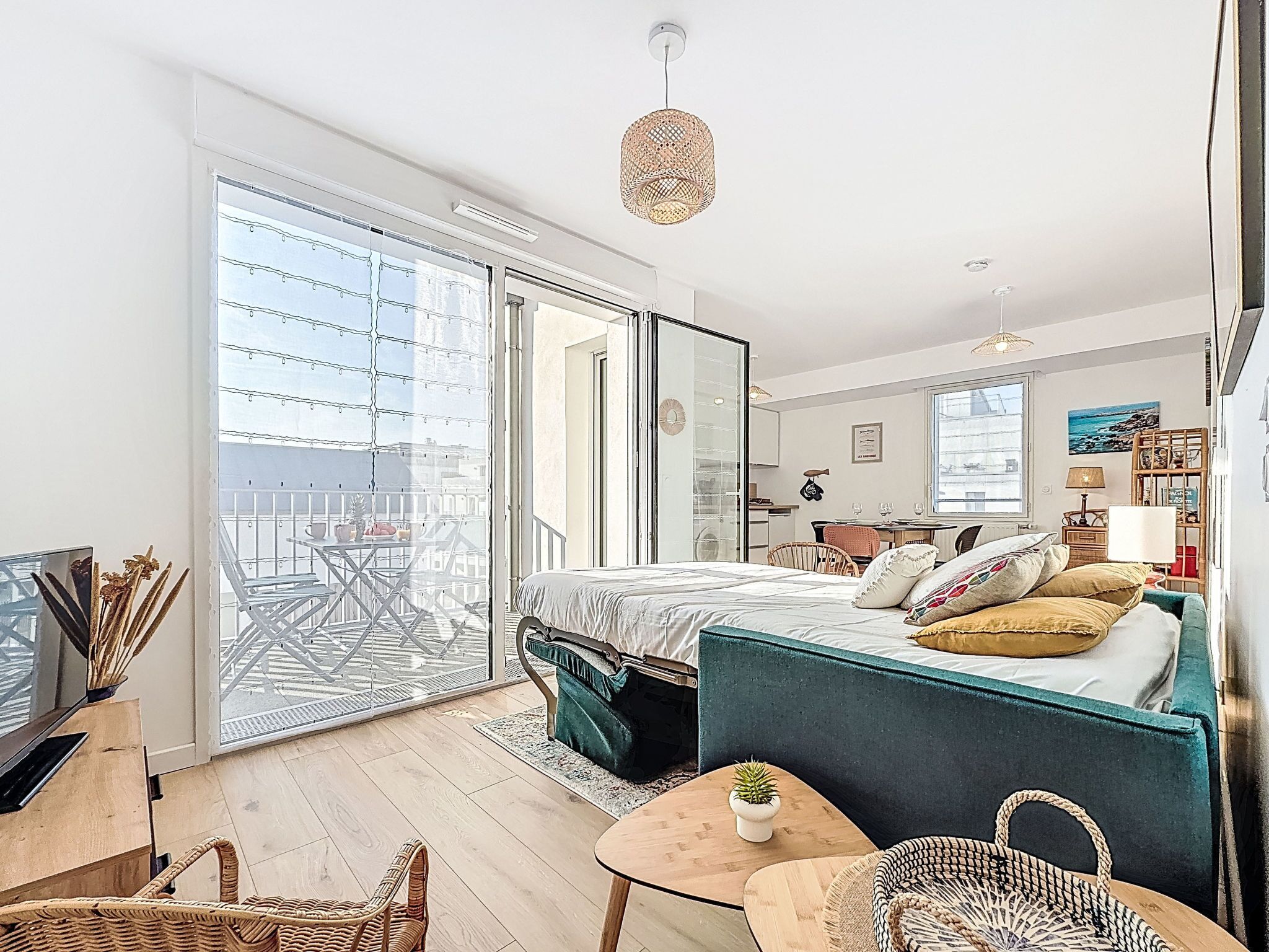 A modern bedroom with a bed, a small table, a chair, and a balcony with a view.
