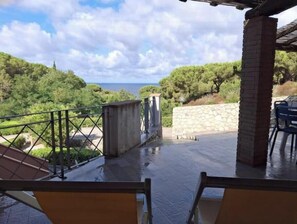 A covered outdoor area with a view of the sea, stone walls, and a metal railing. - Casa Roberta apartment 5 delux (Capoliveri isola d'Elba)