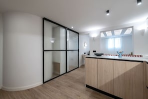 A modern kitchen with a wooden countertop, a large mirror, and a sliding glass door leading to a balcony. - Bright & Stylish 2BR | Jacuzzi | Plaza Spain (Madrid)