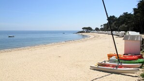 Een strand met een rij kajaks en een hengel.
