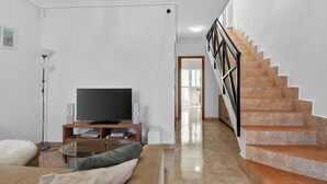 A living room with a TV, speakers, a sofa, a lamp, and a staircase. - La Familia by Interhome (Los Alcázares)