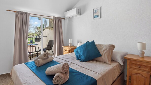 A hotel room with a bed, a nightstand, a chair, and a view of the outdoors. - La Familia by Interhome (Los Alcázares)