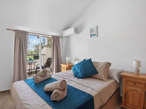 A hotel room with a bed, a nightstand, a chair, and a view of the outdoors. - La Familia by Interhome (Los Alcázares)