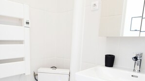 Een badkamer met toilet, wastafel en spiegel.