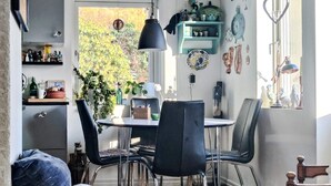 A cozy dining area with a round table, chairs, and a hanging light fixture. - 4 Star Holiday Home in Karna (Kärna)