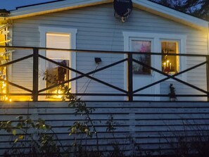 A house with a balcony, a garage door, and a window with a curtain. - 4 Star Holiday Home in Karna (Kärna)