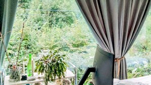 A room with a window, curtains, and a table with plants and candles. - 4 Star Holiday Home in Karna (Kärna)