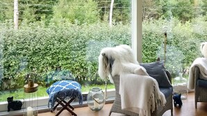 A room with a large window, wicker furniture, a small stool, and a glass jar. - 4 Star Holiday Home in Karna (Kärna)