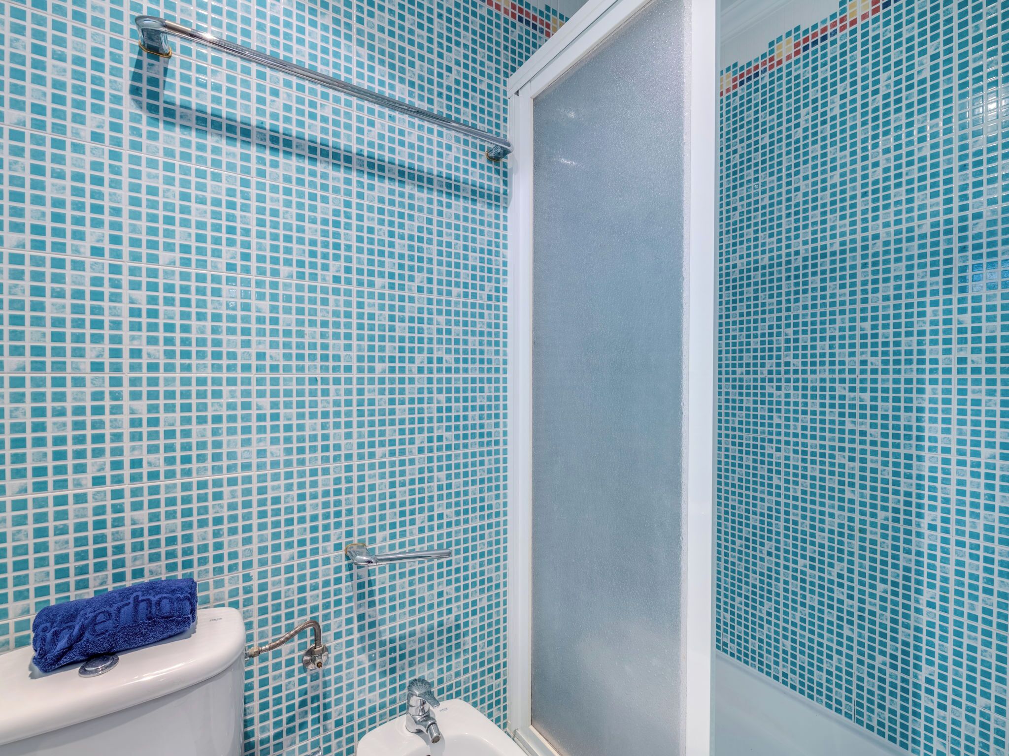 A bathroom with a toilet, sink, and shower area.