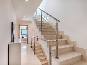 A modern staircase with metal railings and beige steps, leading to a room with a view of the sky. - Colina View by Interhome (Albufeira)